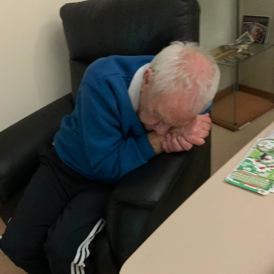 Frank sitting at a table with his head bowed